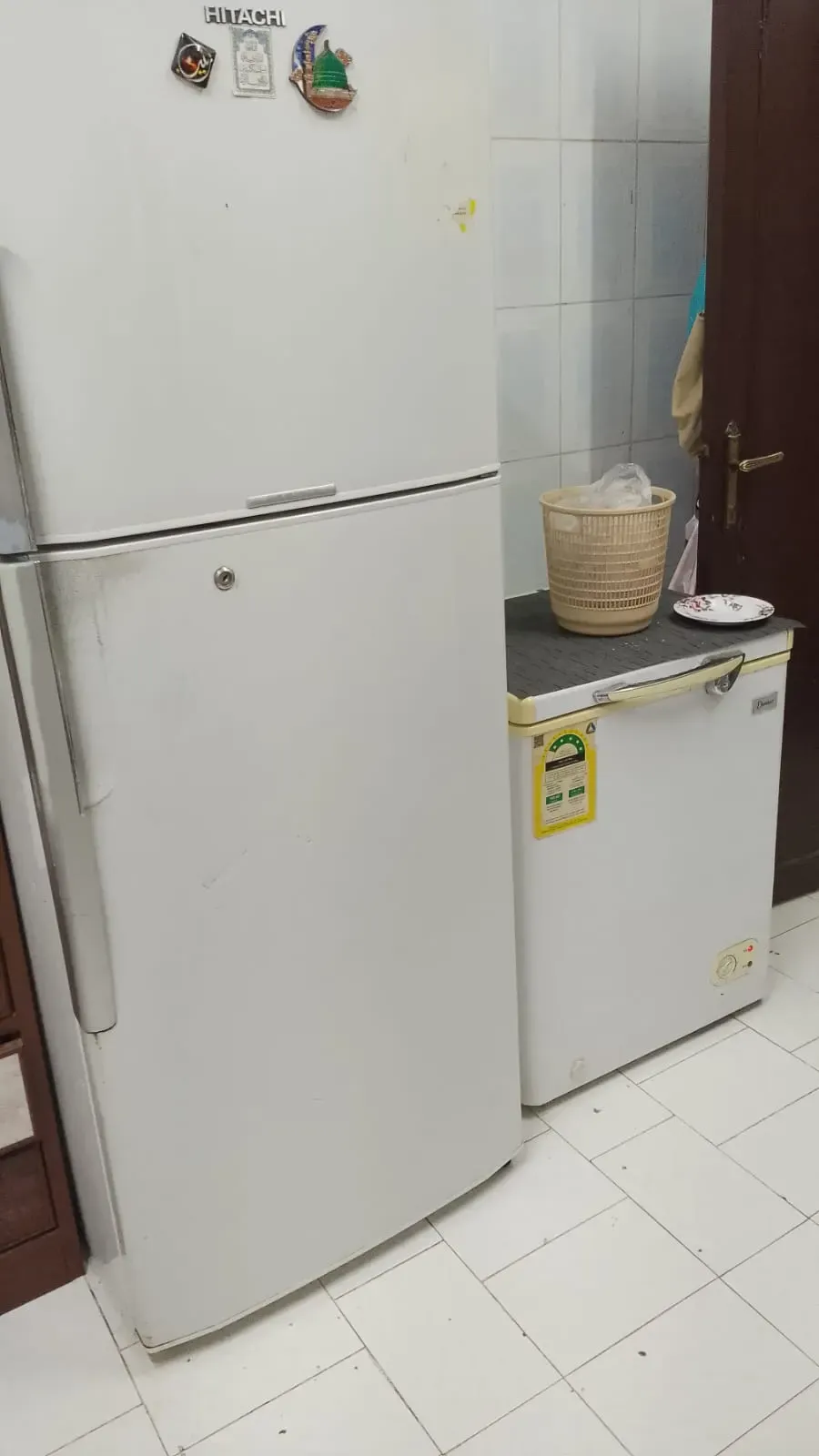 ثلاجة بيضاء طويلة بجانب ثلاجة بيضاء صغيرة.