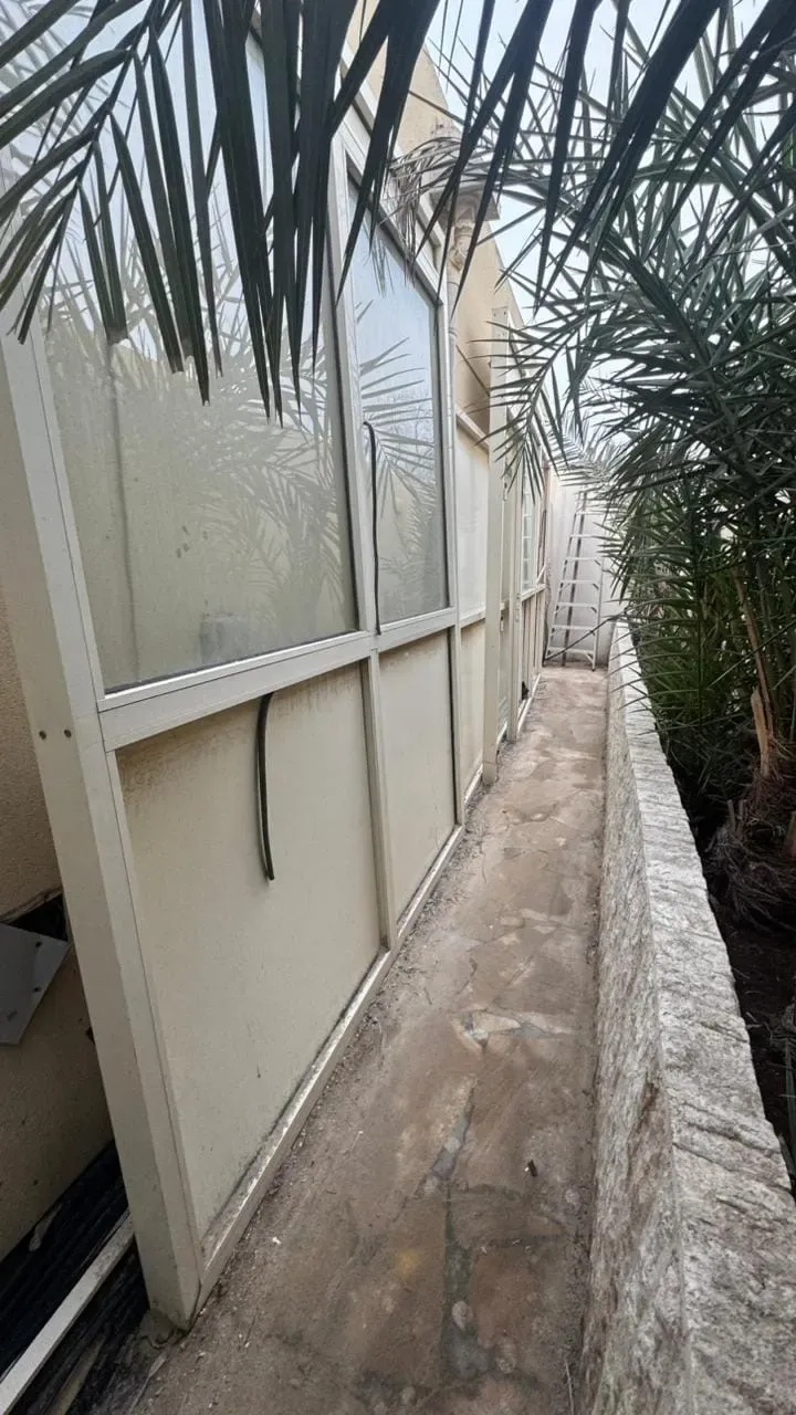 إطارات نوافذ ألمنيوم مسنودة على جدار خارجي.